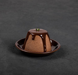 Italian dessert Panna cotta with chocolate sauce on a dark background