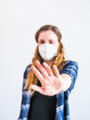 Stopp, junge Frau mit Gesichtsmaske und vor sich ausgestreckter Hand, Coronervirus, Angst vor Ansteckung, Pandemie, Österreich