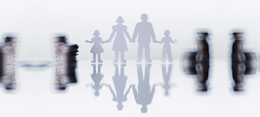 Silhouette of four people and stacks of money. Family concept. Family financial budget. Savings for investment.