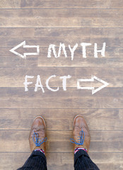 Man standing in front of two arrows and the words "Myth" and "Fact"