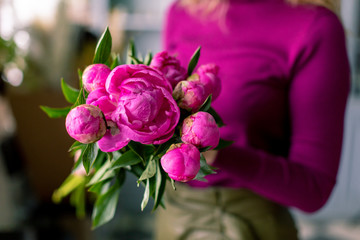 Close-up flowers in hand. Florist workplace. Woman arranging a bouquet with roses, chrysanthemum, carnation and other flowers. A teacher of floristry in master classes or courses