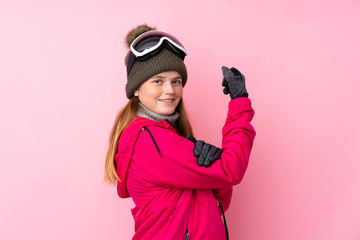 Ukrainian teenager skier girl with snowboarding glasses over isolated pink background making strong gesture