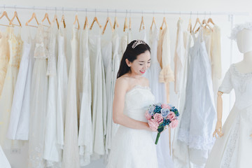 Bride and Bridesmaid Is choosing the bride's dress in the shop to put on his upcoming wedding. Valentines Day Love Concept.