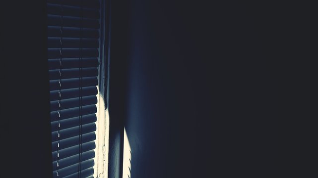 Sunlight Coming Through Window Blinds In Dark Room