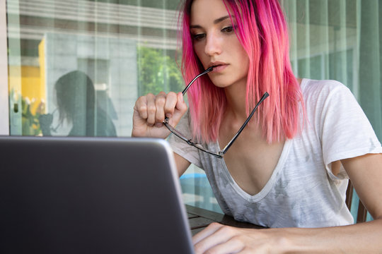 Young Woman With Pink Hair Working With Laptop In Cafe Or Home Terrace