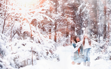 Young family for a walk. Mom and daughter are walking in a winter park.