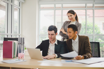 Businessmen are looking at the business plan and business results from the notebook in the office.