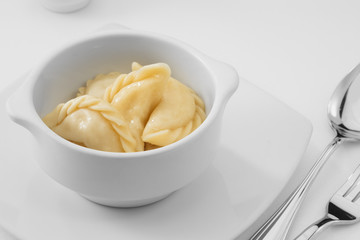 close up view of plate with dumplings  on white background.
