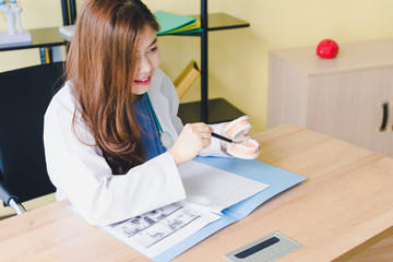 Fototapeta na wymiar Asian beautiful female dentist analyzes and explains the pain of the patient's teeth.