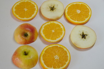 On a white background delicious sliced ​​fruits: apples and oranges.