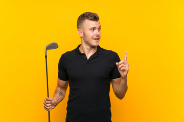 Golfer player man over isolated yellow background intending to realizes the solution while lifting...