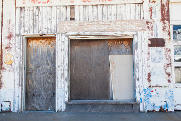 fachada de madera con puertas tapiadas