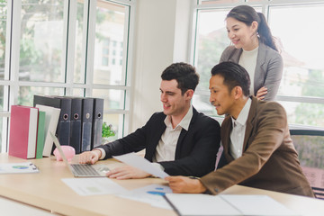 Businessmen are looking at the business plan and business results from the notebook in the office.