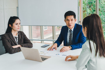 Managers and secretaries meeting and discussing business results from notebooks and paper charging statistics are in the company.