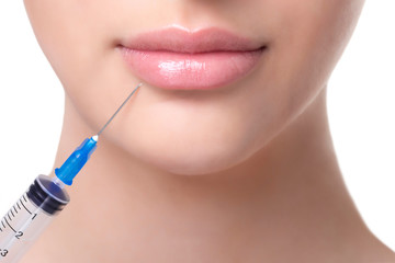 The doctor cosmetologist makes Lip augmentation procedure of a beautiful woman in a beauty...