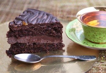 A piece of cake with chocolate filling and a cup of tea