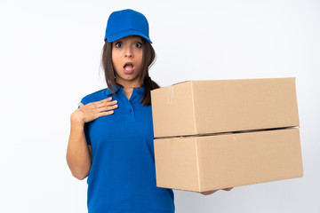 Young delivery brunette girl over isolated white background surprised and shocked while looking right