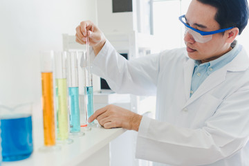 Fototapeta premium Asian scientists are preparing chemicals for testing and analysis in the laboratory. Scientists clear glasses and white shirts. Science and Chemistry Concept