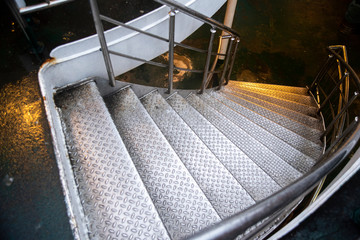 metal stairways to lower deck in a ship  - Powered by Adobe