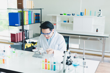 Asian scientists are preparing plant-based materials for testing and analysis in the laboratory. Scientists clear glasses and white shirts. Science and Chemistry Concept