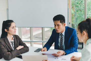 Managers and secretaries meeting and discussing business results from notebooks and paper charging statistics are in the company.