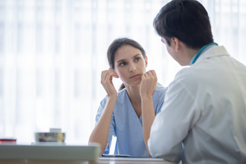 A doctor takes care of a sick patient woman with sadness and unhappiness at the hospital or medical clinic.