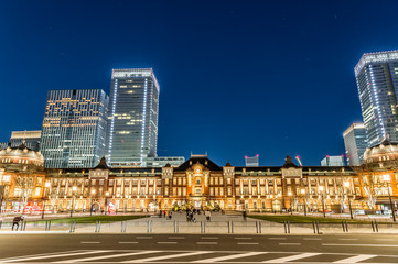Fototapeta na wymiar 東京都千代田区丸の内の夜のライトアップした東京駅と高層ビル群
