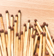 many wooden matches lie on a wooden background. flammable matches on a wooden table.