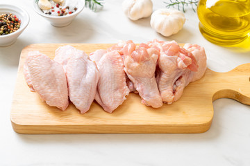 fresh raw chicken wings on wooden board