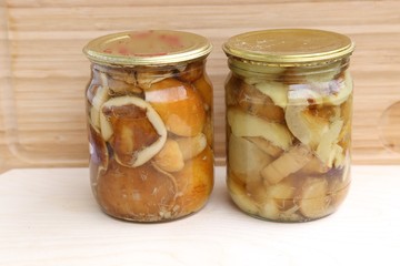 Jars of glass with mushrooms pickled and salty in sauce side view