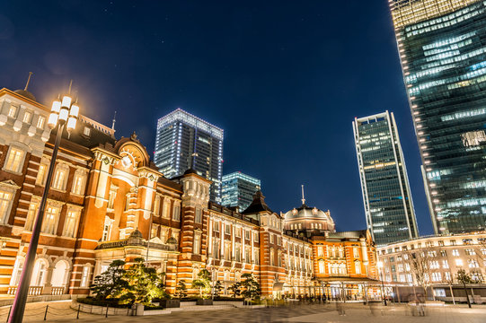 東京都千代田区丸の内の夜のライトアップした東京駅と高層ビル群