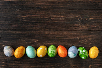 Different easter eggs on wooden background