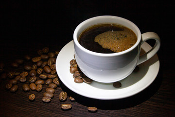 cup of hot coffee and coffee grains on the table