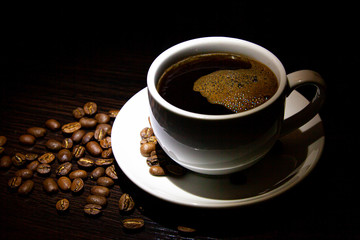 cup of hot coffee and coffee grains on the table