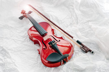 Fototapeta na wymiar Violin and bow put on grunge surface background,Lens flare effect,blurry light around