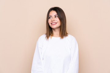 Fototapeta premium Young woman over isolated background laughing and looking up