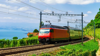 Fototapeta na wymiar Running train and the railroad at Lavaux Vineyard Terraces hiking trail at Lake Geneva and Swiss mountains, Lavaux-Oron district, Switzerland