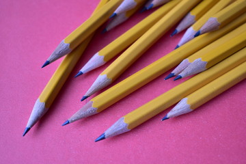 Yellow graphite pencils on a pink background