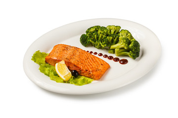 Baked fish salmon garnished with broccoli.