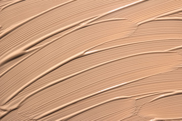 Abstract background with brush strokes. Beige facial foundation cream close up texture. Nude paint smear. Natural cosmetic for female face makeup, tinted cream. Liquid foundation. Background.