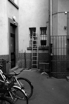 Klappleiter in einem engen alten Hinterhof der gentrifizierten Braubachstra&szlig;e mit Fahrr&auml;dern im Winter in der Altstadt und Innenstadt von Frankfurt am Main in Hessen in neorealistischem Schwarzwei&szlig;