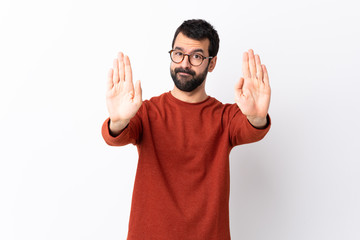 Caucasian handsome man with beard over isolated white background making stop gesture and disappointed
