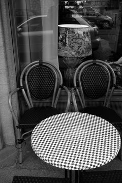Runder Bistrotisch mit Pepitamuster und zwei Bistrost&uuml;hlen vor einem Caf&eacute; und Bistro in der gentrifizierten Braubachstra&szlig;e in der Altstadt von Frankfurt am Main in Hessen in klassischem Schwarzwei&szlig;