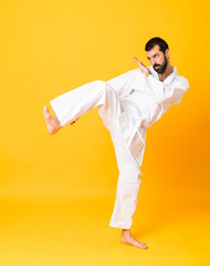 Full-length shot of mandoing karate over isolated yellow background