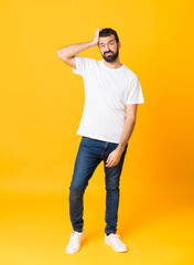 Fototapeta na wymiar Full-length shot of man with beard over isolated yellow background with an expression of frustration and not understanding