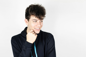 A teenage boy looks away on a light background and seems to be mocking someone. The guy has a...