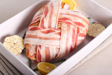 Raw turkey crown wrapped in bacon strips