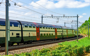 Obraz premium Running train on the railroad in Lavaux Vineyard Terrace hiking trail, Lavaux-Oron district, Switzerland