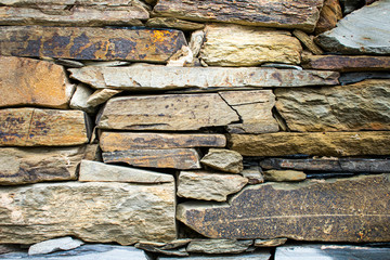 Stone wall built manually and in a traditional way without cement. Abstract background