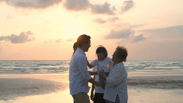 Holiday concept. The big family are happily hugging each other on the beach. 4k Resolution.